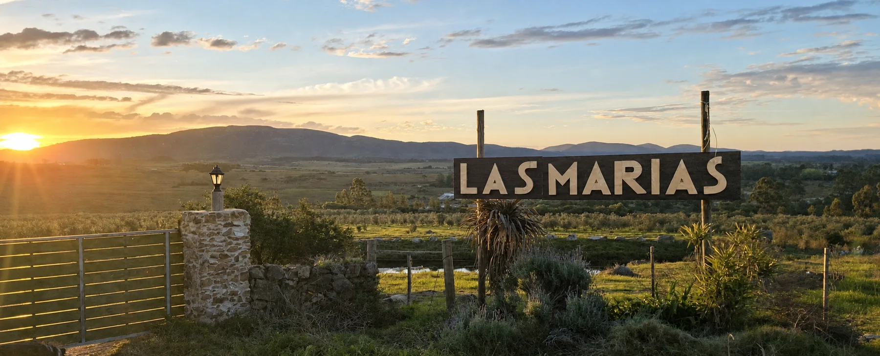El cartel de entrada a Las Marías al atardecer, con las sierras al fondo